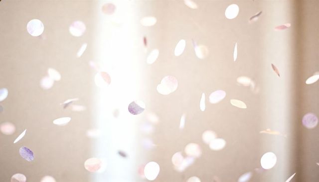 Pastel confetti drifting over soft beige curtain with iridescent bokeh glow