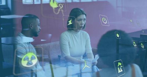 Mid-adult Asian woman reviewing papers during meeting with AR sustainability icons