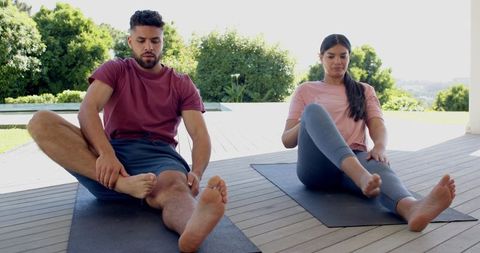 Friends Practicing Yoga Exercises on Sunny Patio