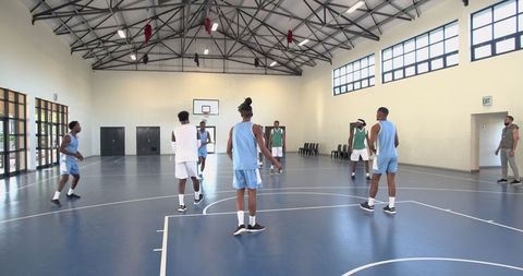 Diverse basketball team practicing in gymnasium