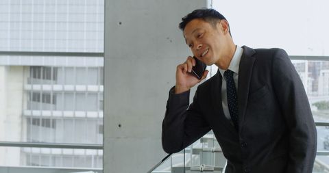 Businessman in Suit Engaged in Serious Phone Call Near Office Window - Download Free Stock Images Pikwizard.com