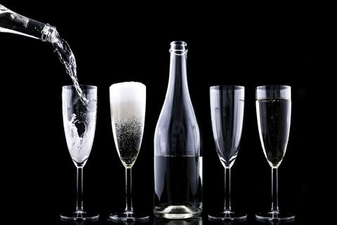 Champagne Pouring Sequence with Bottle and Four Flutes on Black Backdrop