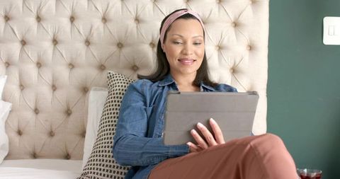 Asian Woman Using Tablet in Comfortable Bedroom Setting