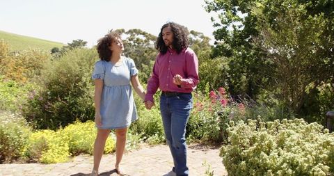 Couple Enjoying Leisurely Stroll in Lush Sunny Garden
