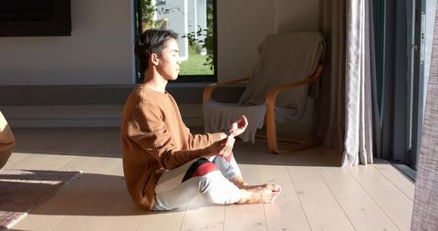 Serene Meditation by Sunlit Glass Door in Morning Light