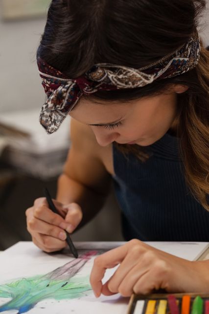 Attentive woman drawing on book in drawing class