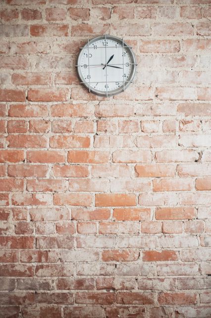 Vintage wall clock hanging on red brick wall, adding a rustic and industrial feel. Background shows time concept, minimalistic interior decoration. Perfect for use in design inspiration, interior decor, time management themed content.