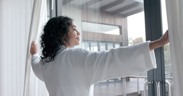 Woman in Bathrobe Opening Curtains in Modern Apartment - Download Free Stock Images Pikwizard.com