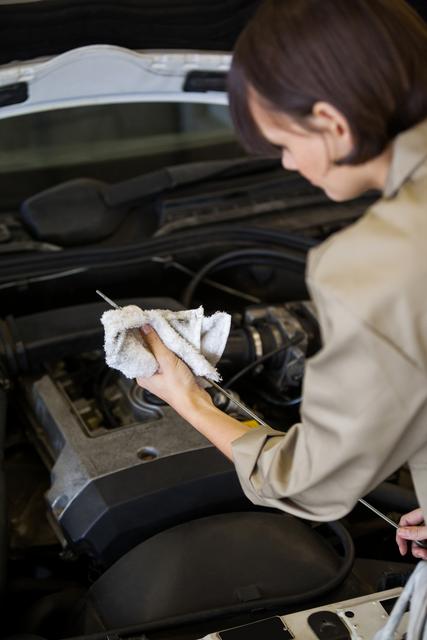 Female mechanic checking the oil level in a car engine - Download Free Stock Photos Pikwizard.com