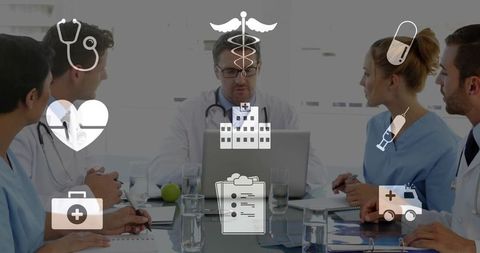 Medical team collaborating around laptop displaying digital healthcare icons and records