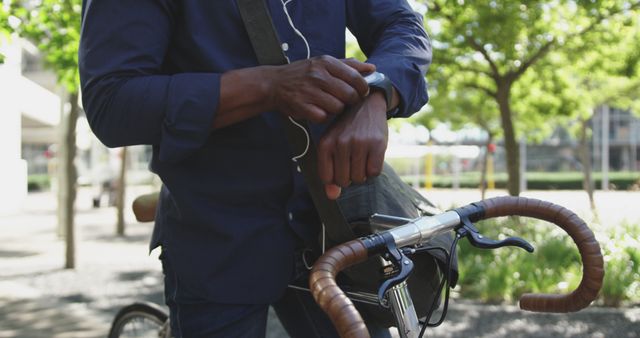 Man Checking Smartwatch While Standing with Bicycle Outdoors - Download Free Stock Images Pikwizard.com