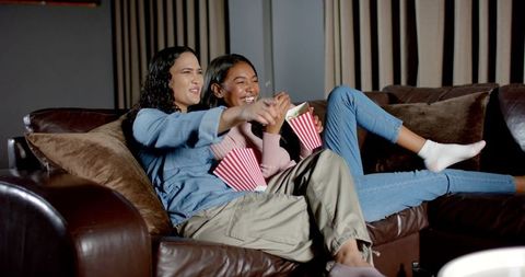 Friends enjoying movie night with popcorn at home