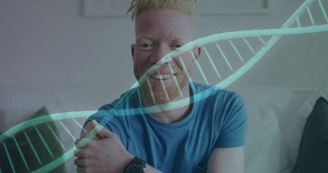 Smiling man sitting on sofa wearing blue t-shirt with dna helix overlay for genomics and health
