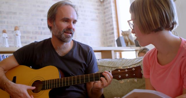 Man Teaching Guitar to Young Woman at Home - Download Free Stock Images Pikwizard.com