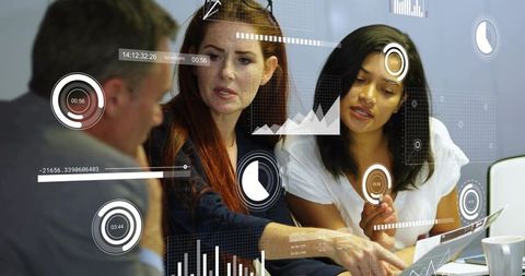 Diverse team collaborating on digital analytics dashboards with laptop and printed reports