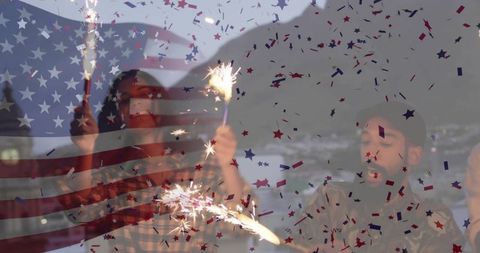 Friends celebrating with sparklers on festive dusk shore