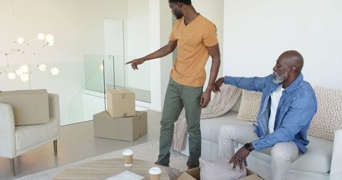 African American Father and Son Unpacking in Modern Living Room