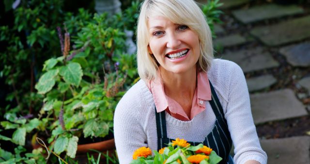 Smiling Woman Gardening with Yellow Flowers in Backyard Garden - Download Free Stock Images Pikwizard.com