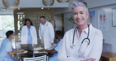 Senior female doctor leading multidisciplinary medical team meeting in modern clinic