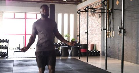 Determined athlete jumping rope in industrial gym