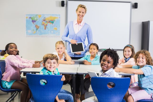Teacher standing with diverse group of smiling students in classroom. Ideal for educational materials, school advertisements, and articles on diversity in education.