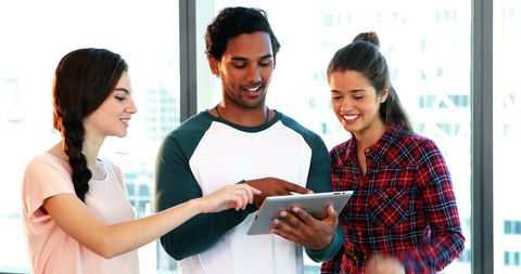 Diverse Young Professionals Collaborating with Tablet in Modern Office - Download Free Stock Images Pikwizard.com