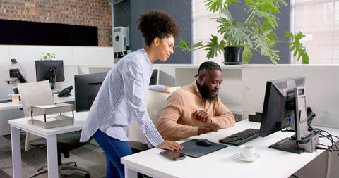 Colleagues Collaborating on Project at Modern Office Workspace