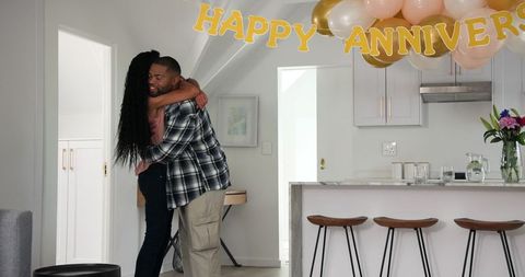Happy couple hosting surprise anniversary celebration at home