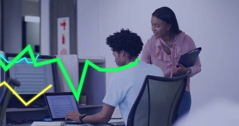 Collaborating over data on laptop with neon analytics overlay in modern office workspace