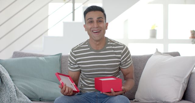 Excited Man Holding Open Gift Box in Living Room - Download Free Stock Images Pikwizard.com