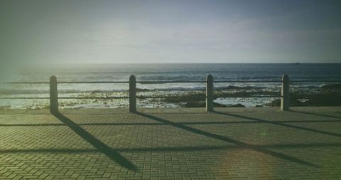 Sunny Coastal Promenade with Ocean View and Shadows