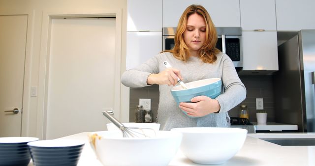 Woman Mixing Ingredients in Modern Kitchen - Download Free Stock Images Pikwizard.com