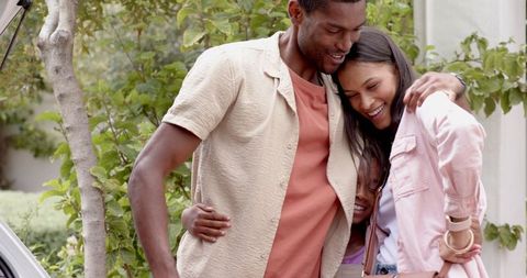 Joyful Family Embracing Together Outdoor with Open Car