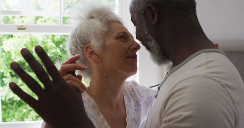 Senior Couple Joyful Dancing at Home in Bright Kitchen