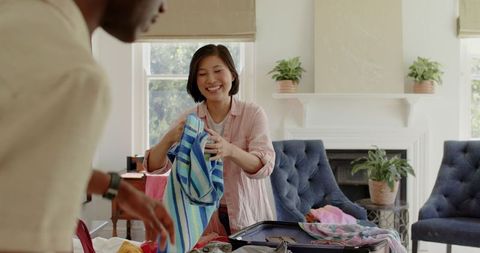 Couple Packing Suitcase for Romantic Trip in Cozy Bedroom