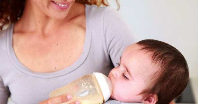 Smiling Mother Feeding Baby with Bottle - Download Free Stock Images Pikwizard.com