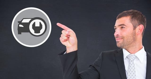 Businessman in professional suit pointing at car repair icon on black background. Ideal for automotive service promotion, business advertisements, tutorials on car maintenance, or illustrating business concepts in automotive industry.
