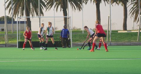 Caucasian Female Hockey Team in Action on Outdoor Court at Sunset - Download Free Stock Images Pikwizard.com
