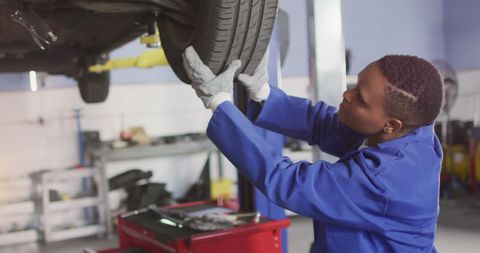 Mechanic Inspecting Car Wheels in Auto Workshop - Download Free Stock Images Pikwizard.com