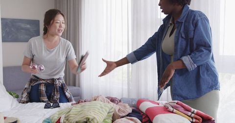 Interracial Lesbian Couple Packing for Vacation at Home