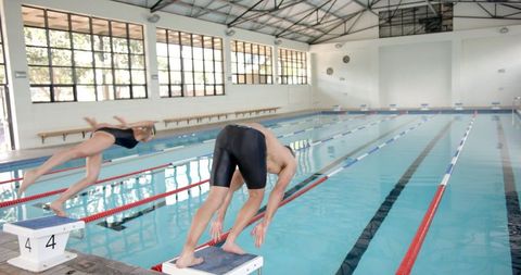 Athletes diving into pool for professional swimming training