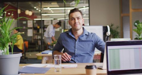 Confident Businessman Seated at Desk in Modern Office - Download Free Stock Images Pikwizard.com