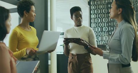 Professional Women Discussing Business Strategies in Modern Office