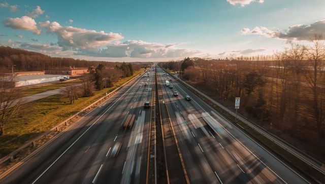 Golden hour motion blur on highway from overpass showing fast traffic and leading lines