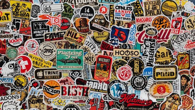 Colorful vintage sticker collage covering cafe wall with vinyl labels and bold typography