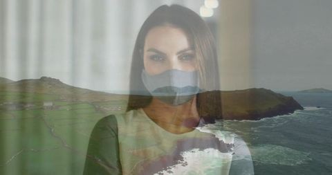 Contemplative woman behind mask with coastal visions overlaid