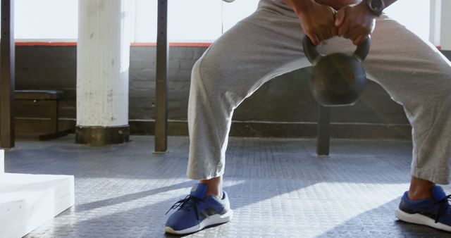 Man Lifting Kettlebell in Gym with Focus on Lower Body - Download Free Stock Images Pikwizard.com