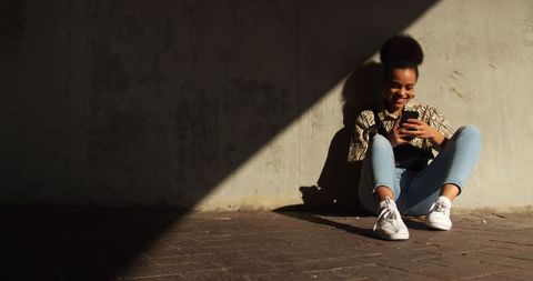 Happy Biracial Woman Relaxing with Smartphone Outdoors - Download Free Stock Images Pikwizard.com