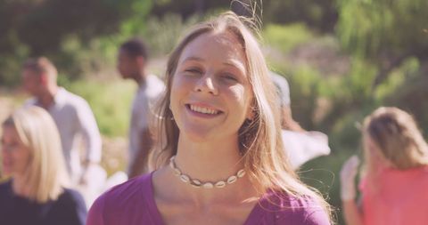 Young Woman Enjoying Sunny Social Gathering in Park