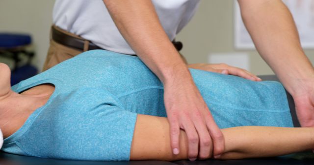 Therapist performing physical therapy on patient's arm in clinical setting. Ideal for articles or promotional materials on physical therapy, rehabilitation, healthcare services, and techniques for pain relief and recovery.